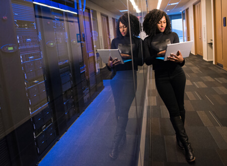 Lady with laptop stood next to server room - Digital transformation