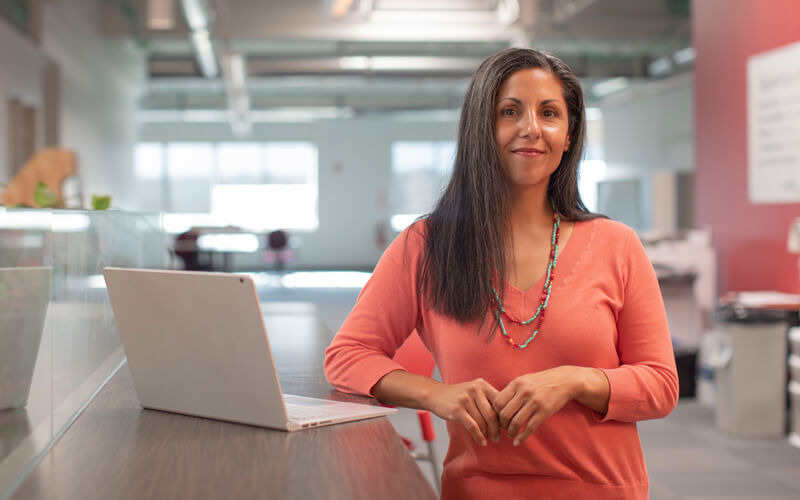 Lady-stood-next-to-laptop-on-desk-Technology-Talk-Distribution